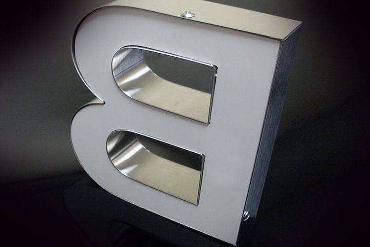 Semelle PVC à l’arrière d’une lettre relief, fixation par vis cruciforme