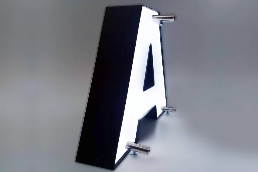 Montage d’une enseigne lumineuse sur support avec écarteurs et câblage préparé