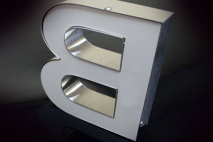 Semelle PVC à l’arrière d’une lettre relief, fixation par vis cruciforme