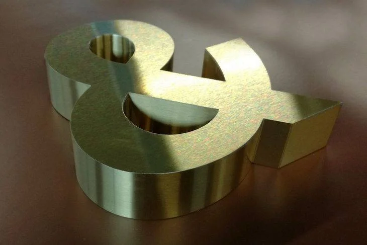 enseigne en titanium gold brossé